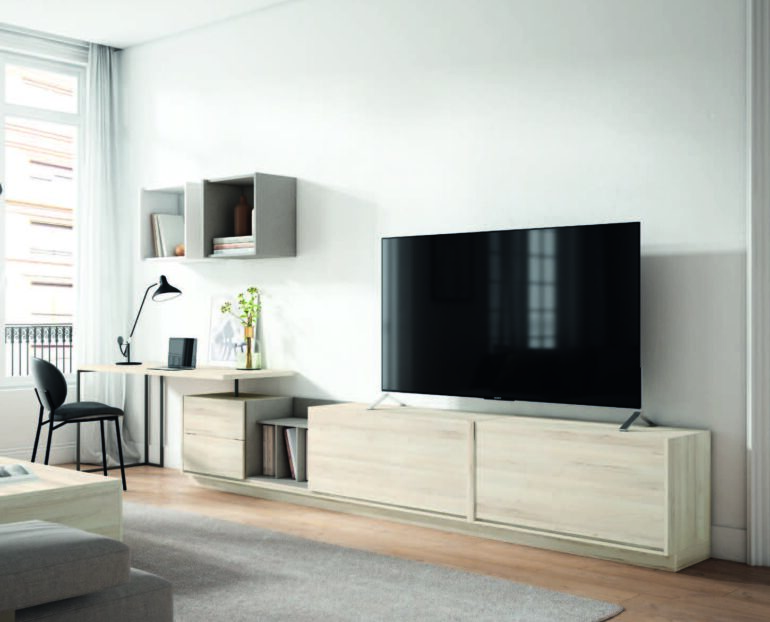 Modern living room with a large flat-screen TV on a light wood console and grey rug area.