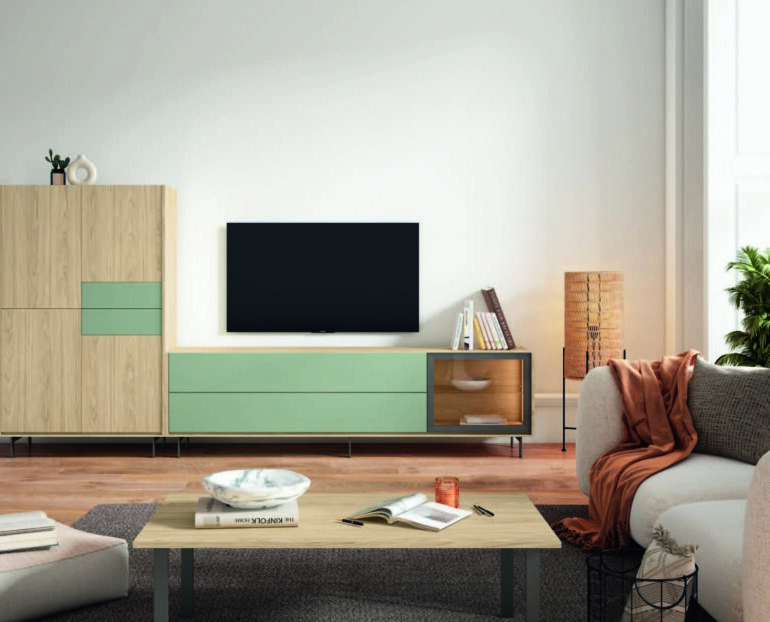 Living room scene with a wall-mounted flat-screen TV on a light wood and mint-green storage cabinet, beige sofa, and plants by a bright window.